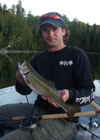 Angler holding an Aurora trout on the water.
